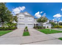 Two-story townhome with gray exterior, two-car garage, and landscaped yard at 15223 Windmill Harbor Ct, Orlando, FL 32828