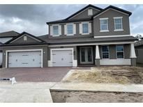 Two-story house with gray siding, three-car garage, and a partially landscaped yard at 2522 Cedar Shake Ct, Oviedo, FL 32765