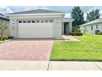 Single-story home with a two-car garage and landscaped lawn at 3201 Songbird Cir, Harmony, FL 34773