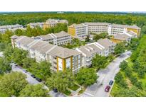 An aerial view of a condo complex surrounded by lush greenery and mature trees at 1401 Celebration Ave # 402, Celebration, FL 34747