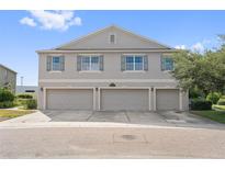 Two-story townhome featuring a three-car garage and neutral-colored exterior with light-blue shutters at 3617 Seneca Club Loop # 7-101 A, Orlando, FL 32808