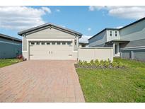 Charming home featuring a spacious two-car garage with a brick paver driveway and manicured lawn at 510 Kennedy Dr, Lake Alfred, FL 33850