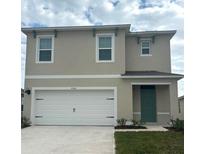 Two-story house with white garage door and green front door at 7150 Cattle Egret Dr, Saint Cloud, FL 34773