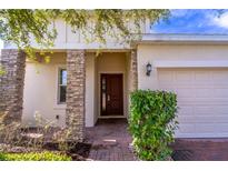 Charming front entrance with brick columns, a brick walkway, and a dark wood front door at 992 Jetway St, Orange City, FL 32763