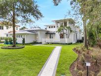 Modern two-story home with landscaped lawn and walkway at 210 Chelton Cir, Winter Park, FL 32789