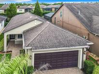 Charming home featuring a spacious garage, paver driveway and walkway, and lush tropical landscaping at 515 Pamplona Pl, Davenport, FL 33837