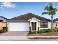 One-story home with white garage door, gray front door, and landscaped yard at 258 Vizcay Way, Davenport, FL 33837