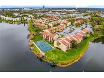 Aerial view of lakefront condos with a tennis court, mature landscaping and ample parking at 588 Orange Dr # 131, Altamonte Springs, FL 32701