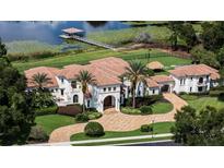 Stunning lakefront estate with a tile roof, lush landscaping, private dock, and sports court at 1965 Lake Markham Preserve Trl, Sanford, FL 32771