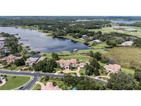 Expansive aerial view of a waterfront estate with lush landscaping, pool, and lake access at 1965 Lake Markham Preserve Trl, Sanford, FL 32771