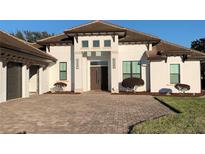 Exterior of a single-story home with paver driveway and landscaping at 816 Johns Point Dr, Oakland, FL 34787