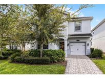 Two-story house with gray exterior, two-car garage, and landscaping at 1638 Moon Valley Dr, Davenport, FL 33896
