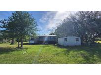 Charming home with a spacious front yard and shed surrounded by mature trees, offering a serene setting at 2661 Waccassa St, Geneva, FL 32732