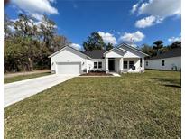 Charming single-story home with a bright white exterior, attached garage, and a well-manicured lawn at 292 Kimble Ave, Oviedo, FL 32765