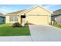 Charming one-story home featuring an attached two-car garage, well-maintained lawn, and manicured landscaping at 4284 Sagefield Dr, Harmony, FL 34773