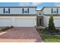 Charming two-story townhome with a brick driveway and attached two-car garage at 4316 Ranch House Rd, Saint Cloud, FL 34772