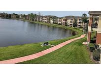 Scenic lake view with walking path, bench, and multi-story residential buildings in a well-maintained community at 1909 Summer Club Dr # 307, Oviedo, FL 32765