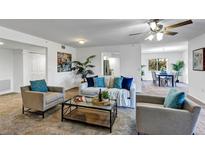 Bright living room features plush seating, ceiling fan, and an open floor plan leading into the dining area at 1150 Carmel Cir # 201, Casselberry, FL 32707