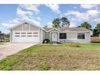 Charming single-story home with a two-car garage, manicured lawn, and welcoming front entrance at 3186 Mapleshade St, Deltona, FL 32738