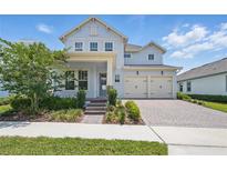 Charming two-story home with a brick driveway, manicured landscaping, and attached two-car garage at 13163 Mcmillan Dr, Orlando, FL 32827
