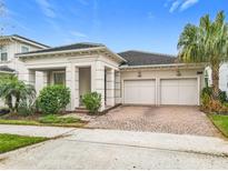 Elegant single-Gathering home featuring a brick driveway and two-car garage at 8325 Topsail Pl, Winter Garden, FL 34787