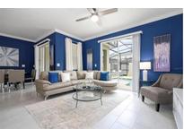 Bright living room with stylish furniture, modern decor, and sliding glass doors to the pool at 2709 Scrapbook St, Kissimmee, FL 34746