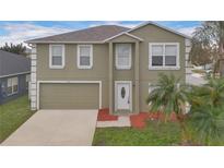Two-story home featuring an attached garage, a well-kept lawn, and a freshly painted exterior at 1103 Epson Oaks Way, Orlando, FL 32837