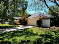 Charming home featuring a large garage and well-manicured lawn with mature trees, enhancing its curb appeal at 10161 Culpepper Ct, Orlando, FL 32836