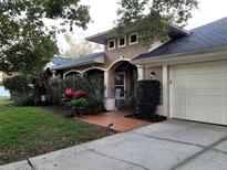 Charming home features a well-manicured front yard and inviting entryway with brick-look tile at 10161 Culpepper Ct, Orlando, FL 32836
