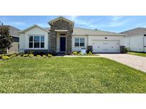 Charming single-story home featuring a well-manicured lawn and beautiful stone accents at 329 Lady Palm St, Apopka, FL 32703