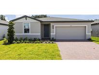 One story home with gray exterior, two car garage, and landscaped lawn at 5174 Minneola Ln, Saint Cloud, FL 34772