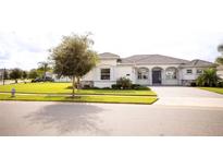 Single-story home with a tile roof, landscaped yard, and driveway at 1424 Olympic Club Blvd, Champions Gate, FL 33896