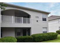 Two-story building exterior with balcony, landscaping, and building number 570 at 570 Cranes Way # 248, Altamonte Springs, FL 32701