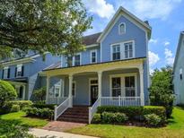 Charming two-story home featuring a covered porch with classic columns and landscaped front yard at 2072 Hartz Aly, Orlando, FL 32814