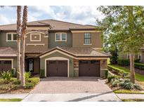 Beautiful multi-story townhome with a brick driveway and two car garage at 8930 Azalea Sands Ln, Davenport, FL 33896