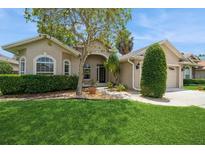 Charming single-story home featuring a well-manicured lawn, mature trees, and a welcoming facade at 2657 Queen Mary Pl, Maitland, FL 32751