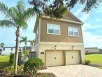 Inviting exterior with a two-car garage and manicured landscaping at 7465 Excitement Dr, Reunion, FL 34747