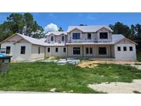 New construction home featuring a modern elevation, large windows, and a covered front porch at 405 Long And Winding Rd, Howey In The Hills, FL 34737