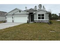 Two-car garage and neutral colored exterior at 300 Barebow Ln, Ormond Beach, FL 32174