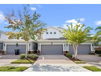Two-story townhome with gray garage doors and landscaping at 612 Terrace Spring Dr, Orlando, FL 32828