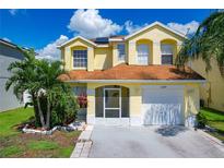 Two-story yellow house with solar panels, screened porch, and landscaped yard at 1389 Ivy Meadow Dr, Orlando, FL 32824