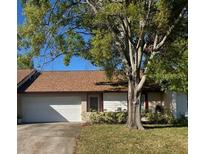 Cozy one-story home featuring an attached garage, a brown roof, and a lush green lawn at 102 Oakridge Ct, Sanford, FL 32773