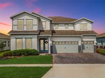 Charming two-story home featuring a three-car garage, beautiful landscaping, and an inviting entrance with double doors at 3198 Sailing Pier Ave, Winter Garden, FL 34787
