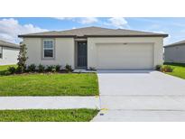 Inviting single-story home with a well-manicured lawn, tidy landscaping, and a convenient two-car garage at 1344 Oak Valley Dr, Auburndale, FL 33823