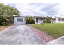 Charming single-story home features a well-maintained lawn, brick walkway, and lovely curb appeal at 2819 Pembrook Dr, Orlando, FL 32810