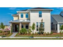 Two-story home featuring a stone and siding exterior, a covered entryway, and manicured landscaping at 10257 Medawar St, Orlando, FL 32827