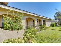 Charming, beige stucco home featuring arched entryways, lush landscaping, and a well-manicured lawn at 206 Diamond Cv # 108, Casselberry, FL 32707