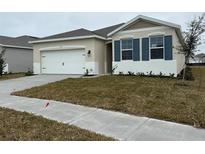 One-story home with a white exterior, two-car garage, and landscaping at 334 Rover Rd, Ormond Beach, FL 32174