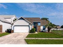 Charming single-Gathering home featuring a two-car garage, well-maintained lawn, and inviting curb appeal at 10557 Glassborough Dr, Orlando, FL 32825