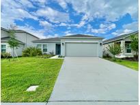 Charming single-story home with a well-manicured lawn and a two-car garage at 1393 Asher Mason Ave, Kissimmee, FL 34744